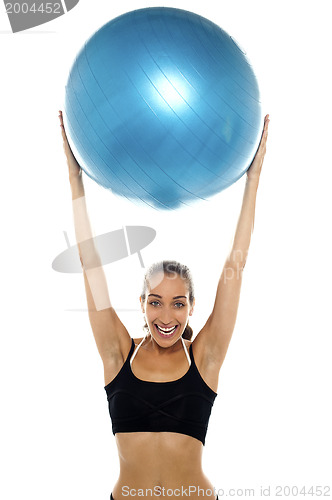 Image of Fit young lady holding up big blue pilates ball