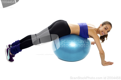 Image of Woman lying over swiss ball to strengthen her abdomen