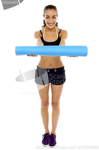 Image of Woman holding a blue mat in her outstretched arms