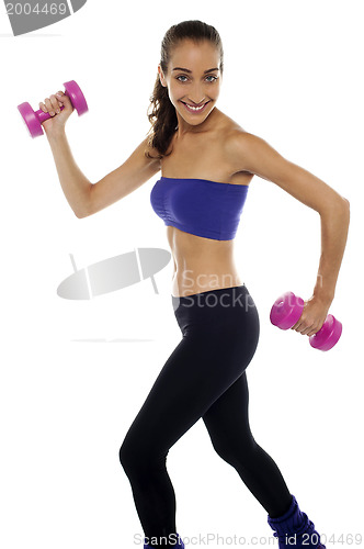 Image of Slim beauty in walking posture, holding dumbbells