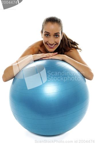 Image of Woman leaning over big blue swiss ball