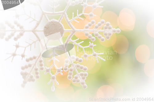 Image of Snowflake Over an Abstract Green and Gold Background