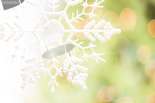Image of Snowflake Over an Abstract Green and Gold Background