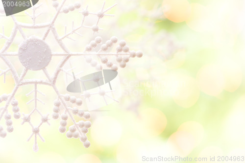 Image of Snowflake Over an Abstract Green and Gold Background