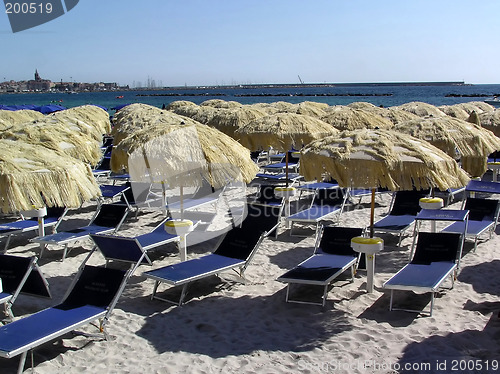 Image of Straw umbrellas and chairs on beach