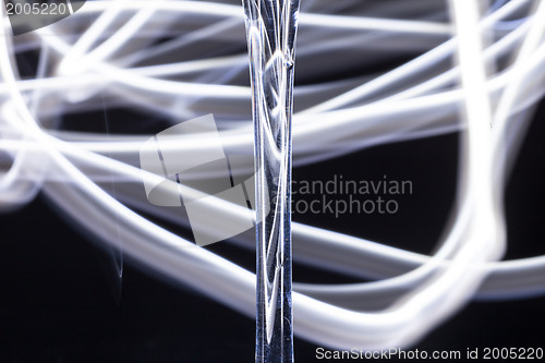 Image of Abstract light tracks behind glass