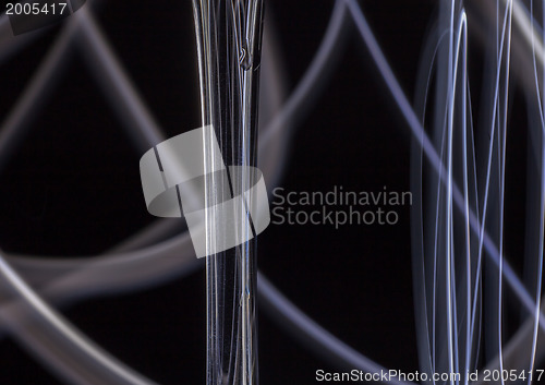 Image of Abstract light tracks behind glass