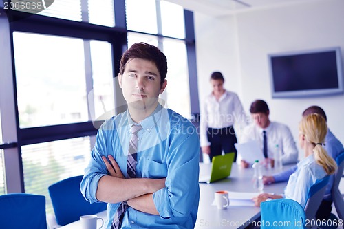 Image of business man  on a meeting in offce with colleagues in backgroun