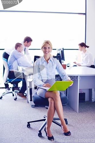 Image of business woman with her staff in background at office
