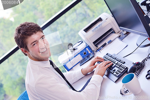 Image of happy young business man at office