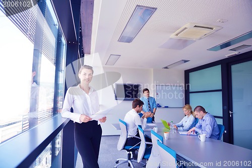 Image of business woman with her staff in background at office