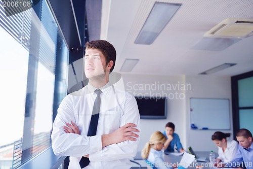 Image of business man  on a meeting in offce with colleagues in backgroun