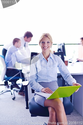 Image of business woman with her staff in background at office