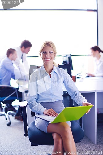 Image of business woman with her staff in background at office
