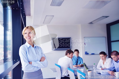 Image of business woman with her staff in background at office