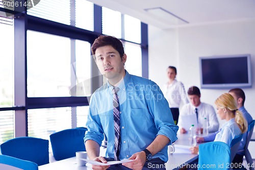 Image of business man  on a meeting in offce with colleagues in backgroun