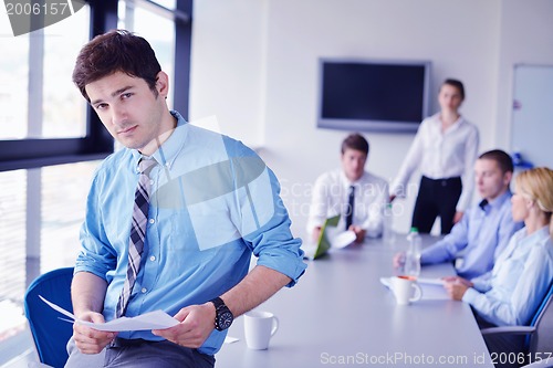 Image of business man  on a meeting in offce with colleagues in backgroun