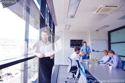 Image of business woman with her staff in background at office