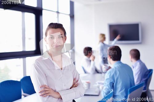Image of business woman with her staff in background at office