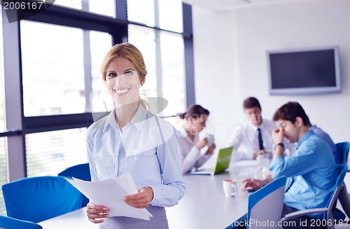 Image of business woman with her staff in background at office