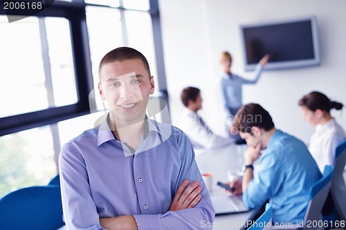 Image of business man  on a meeting in offce with colleagues in backgroun