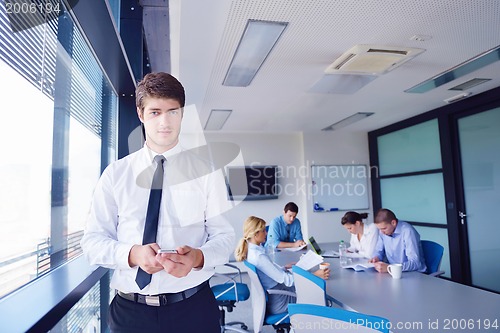 Image of business man  on a meeting in offce with colleagues in backgroun