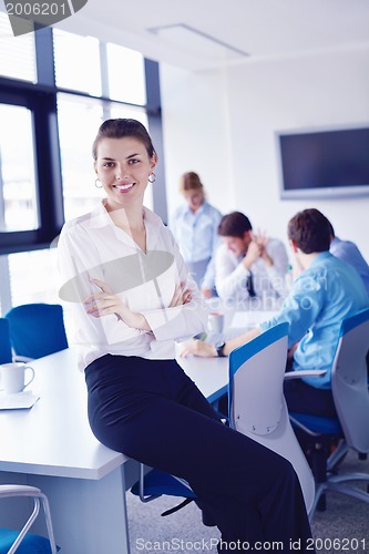 Image of business woman with her staff in background at office