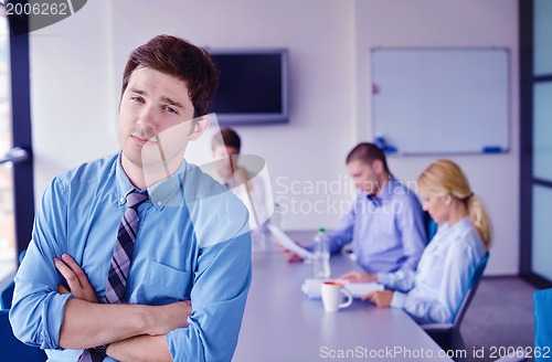 Image of business man  on a meeting in offce with colleagues in backgroun