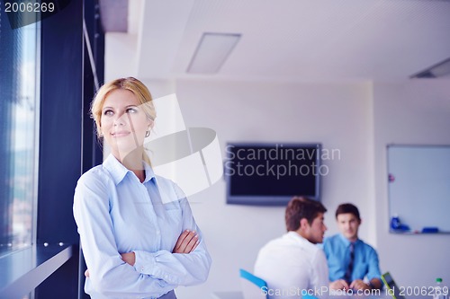 Image of business woman with her staff in background at office