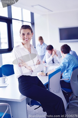 Image of business woman with her staff in background at office