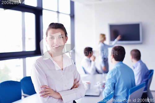 Image of business woman with her staff in background at office