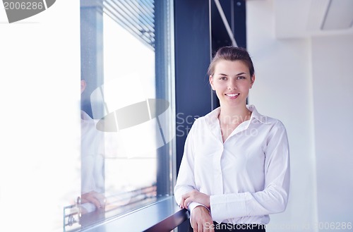 Image of business woman with her staff in background at office