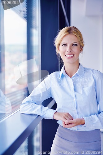 Image of business woman with her staff in background at office