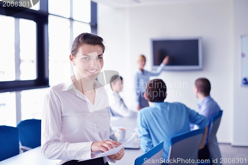 Image of business woman with her staff in background at office