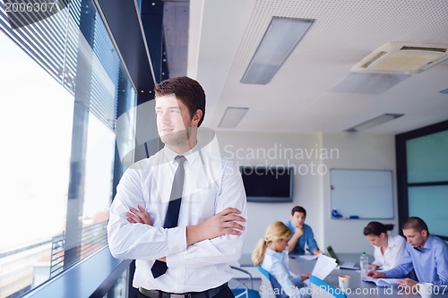 Image of business man  on a meeting in offce with colleagues in backgroun