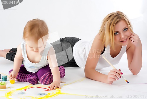 Image of Pretty young mother and daughter drawing