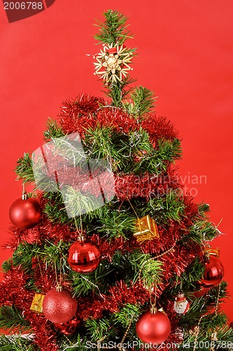Image of Decorated christmas tree on red background
