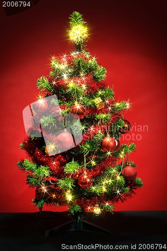 Image of Decorated christmas tree with stars on red background