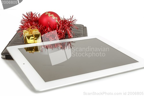 Image of gift white tablet with Christmas ball, box and red chain