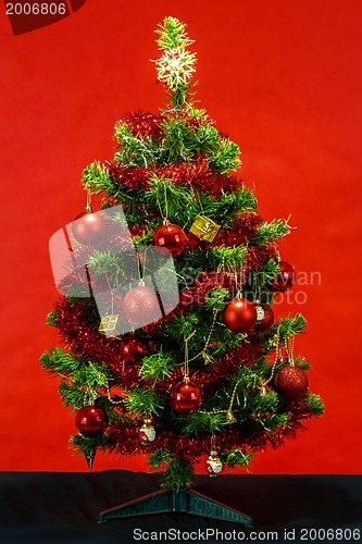 Image of Decorated christmas tree on red background