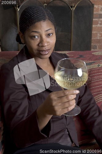 Image of smiling woman on sofa with wine glass