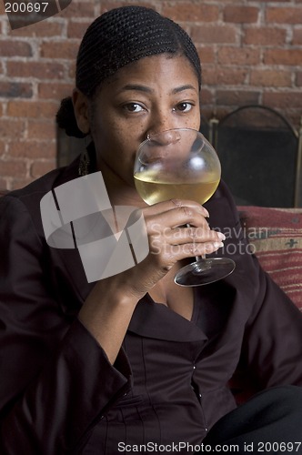 Image of smiling woman on sofa with wine glass