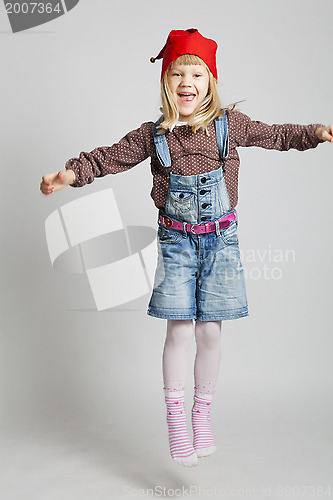 Image of Smiling girl wearing Christmas hat and jumping
