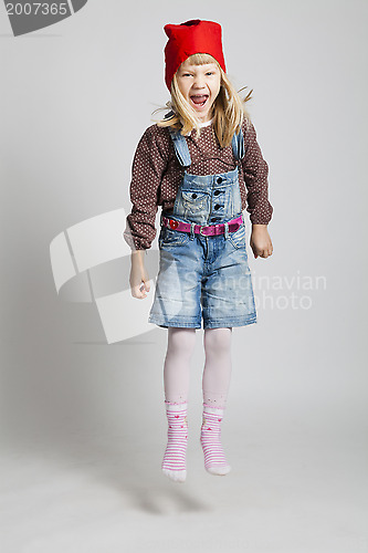 Image of Smiling girl wearing Christmas hat and jumping