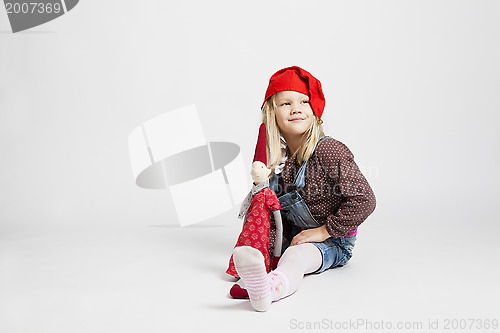 Image of Smiling girl holding Christmas elf doll