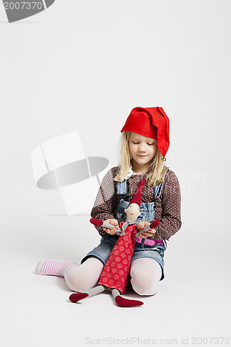 Image of Smiling girl holding Christmas elf doll