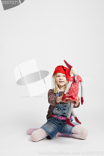 Image of Smiling girl holding Christmas elf doll