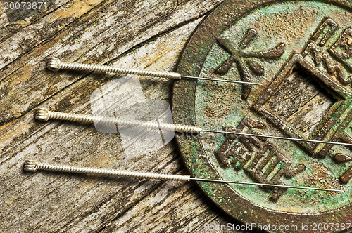 Image of acupuncture needles on chinese coin