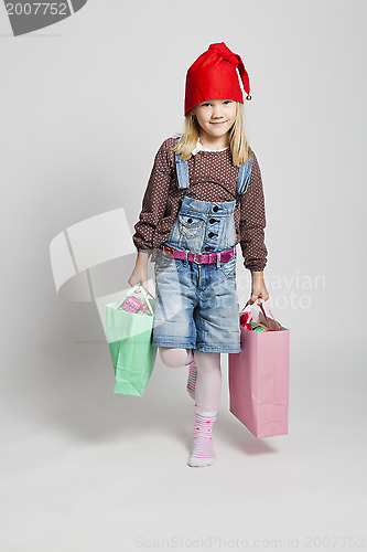 Image of Smiling girl carrying Christmas shopping bags