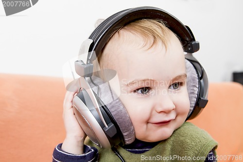 Image of young child on couch with headphone